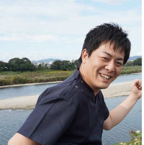 川辺で笑顔を見せる理学療法士